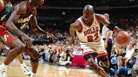 An action shot of Michael Jordan dribbling past Shawn Kemp