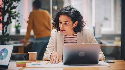 A financial analyst working through some project data on a laptop