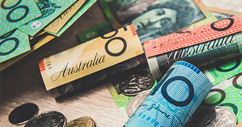 Australian currency laid out over a desk in different denomination notes and coins