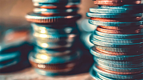 Coins of different denominations and currencies stacked into a pile