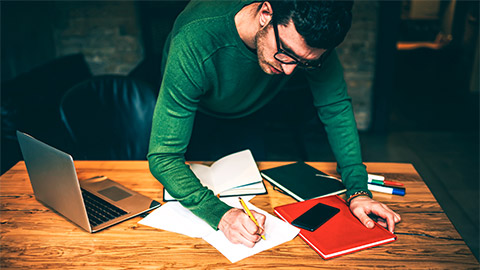 A professional reviewing the notes they've made on the organisation they work for, before submitting their strategy proposal