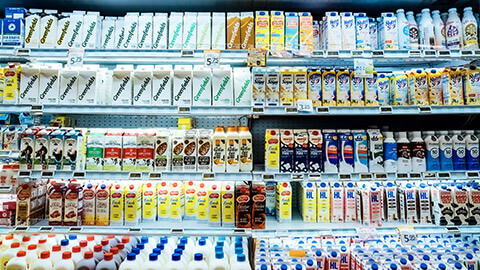 Refrigerated supermarket shelves filled with a variety of a different dairy products