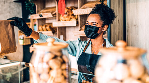 A business owner serving a customer during the Covid-19 pandemic