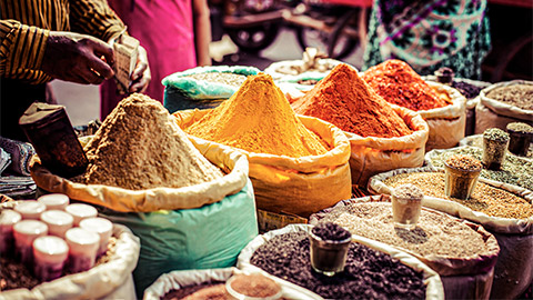 A spice merchant preparing a range of spices for a buyer