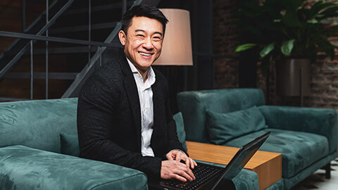 A successful asian businessman sitting on a couch in a modern office