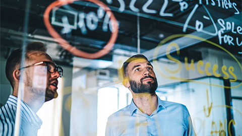 Two team members brainstorming a diagram using colourful chalk pens