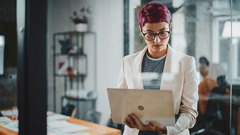 A business analyst looking at info on a laptop