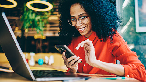 A marketing researcher checking information on a mobile and laptop