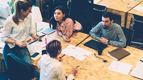 A group of marketers sitting at a table discussing a project