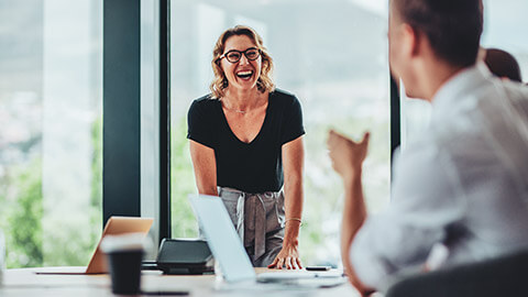 An enthusiastic employee talking to people sitting at a table