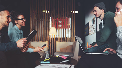 A group of young hipster business people sitting in a modern office discussing strategy