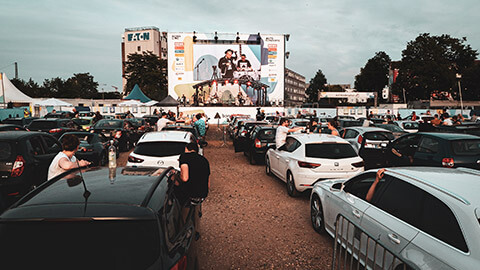 An innovative outdoor concert during COVID where people are staying in their cars to maintain social distance