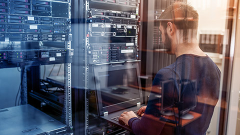 young it engeneer business man with thin modern aluminium laptop in network server room