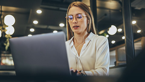 Woman typing on a laptop in a modern workspace