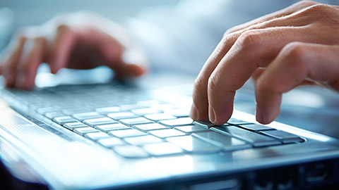 A close view of a person typing on a laptop