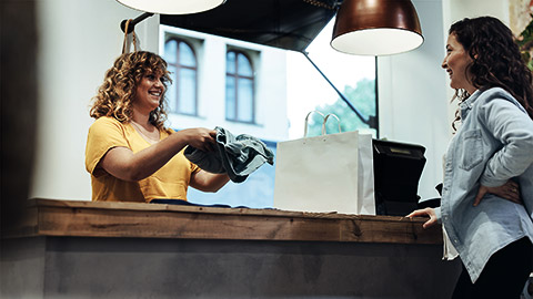 A clerk talking to a customer at the check out counter