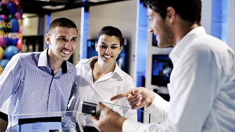 people in consumer electronics retail store looking at latest laptop, television and photo camera to buy