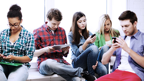 Teens using phones and tablet