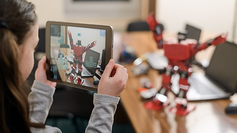 Child playing augmented reality game on tablet