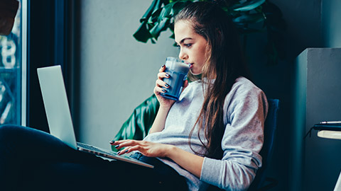 A young gamer checking social media on a laptop and phone