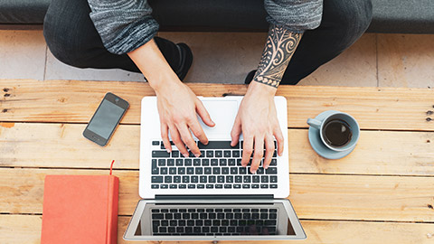 A top down view of a person working on a laptop