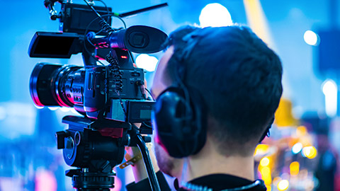 A close view of a broadcast camera person