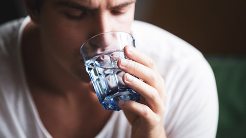 A close view of a dehydrated person drinking water