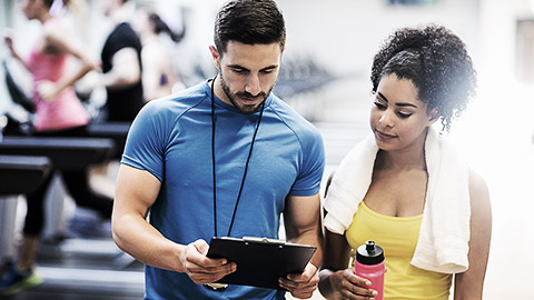 A trainer talking to a client in the gym