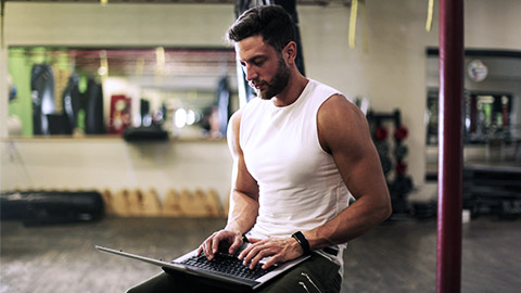 Fitness man using laptop