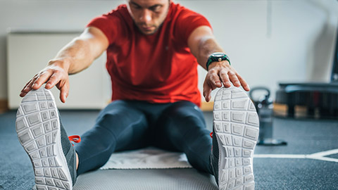 A person stretching in a gym before a workout