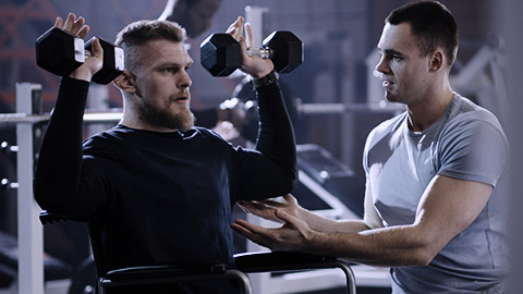 Man on wheelchair lifting in gym