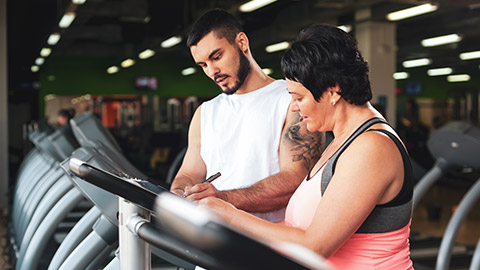 A trainer talking to a client between exercises