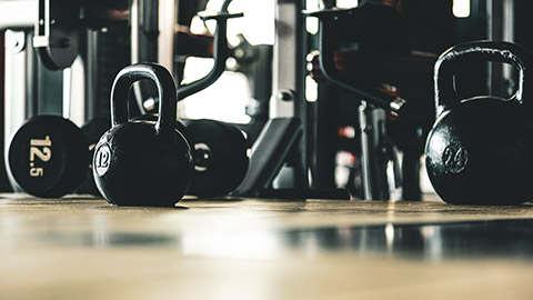 Kettle bells sitting on the floor of a gym