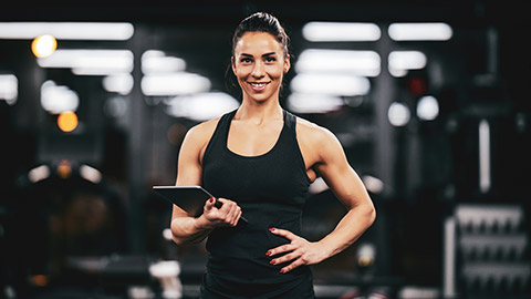 A personal trainer smiling at the camera in a gym