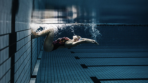 A person jumping off from the wall in a pool