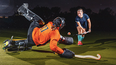 2 people playing field hockey