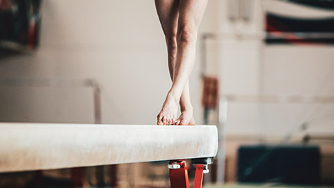 A close view of a person training on a balance beam