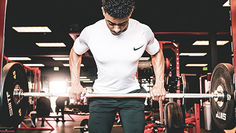 A person doing upright rows in a gym