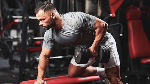 A person doing dumbbell rows in a gym