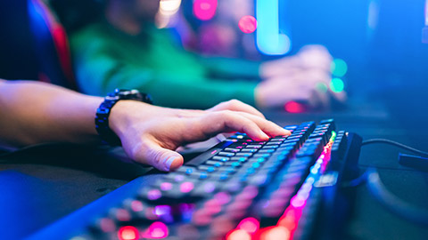 Professional cyber video gamer studio room with personal computer armchair, keyboard for stream in neon color blur background