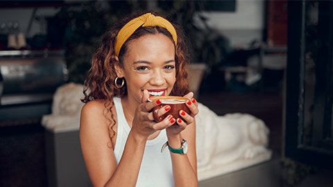 Smile, happy and coffee shop young woman enjoying a cup of tea in a restaurant or cafe