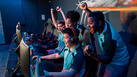 Multiracial team of happy professional cyber sports gamers celebrating success