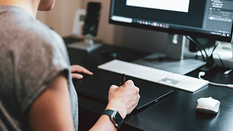 A designer working on a logo using a graphics tablet