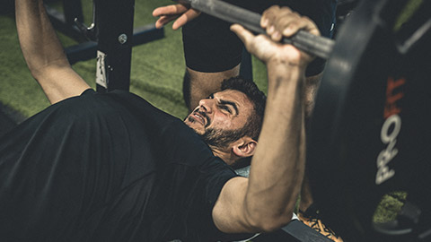 A person straining through a bench press exercise