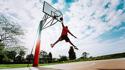 A person about to dunk on an outdoor court