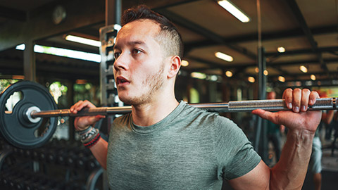 A person in a gym about to do a squat