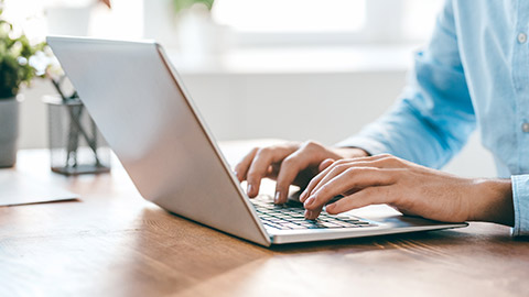 A person typing on a laptop