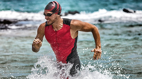 A triathlete running out of the water