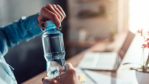 A person with a water bottle in an office setting