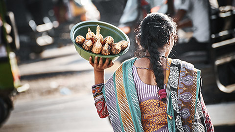 Indian woman carrying roasted corn